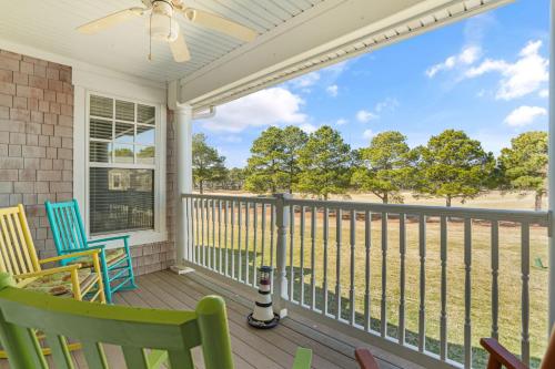 a screened porch with two chairs and a fan at Isla Villa - Comfortable Bay Creek townhome with pools & golf! in Cape Charles