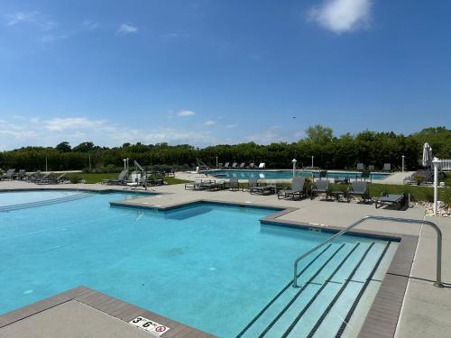 a large pool with blue water in a resort at Isla Villa - Comfortable Bay Creek townhome with pools & golf! in Cape Charles