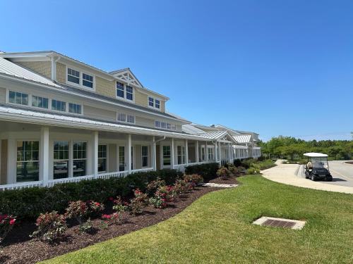 a large house with a lawn in front of it at Isla Villa - Comfortable Bay Creek townhome with pools & golf! in Cape Charles