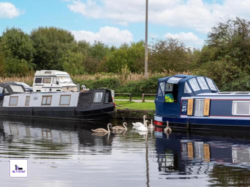 a group of boats and swans in the water at Calder Canal by Alt-Stay - Peaceful 3 Bed Canal Side Cottage Contractor and Relocation Accommodation Wakefield with Stunning Views, Parking, Kitchen, Laundry, Smart TV and Wi Fi - Weekly and Monthly Rates in Wakefield
