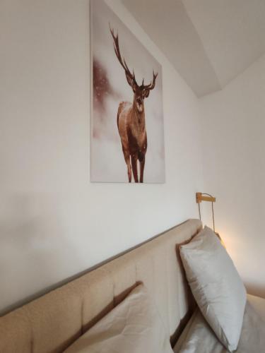 a picture of a deer on a wall above a bed at Le Chalet Champenois - Jacuzzi - Terrasse - Calme - Ciné Netflix in Troyes