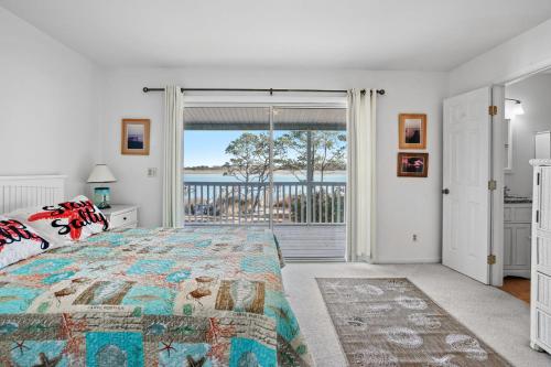 a bedroom with a bed and a view of the ocean at Island Sunrise - Pet friendly, waterfront duplex! in Deep Hole