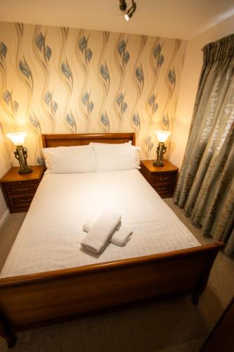 a bedroom with a bed with two towels on it at Harvest House with Games Room in Stirling