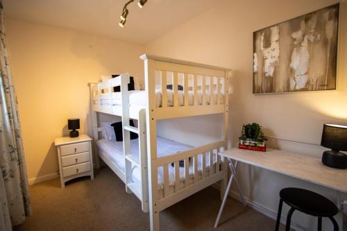 a room with two bunk beds and a desk at Harvest House with Games Room in Stirling