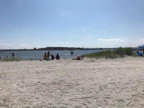 a group of people sitting on a beach near the water at Beautiful Home In Ørsted W- in Ørsted