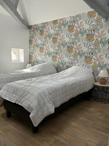 - une chambre avec 2 lits et papier peint à fleurs dans l'établissement Écrin de Loire, à Pouilly-sur-Loire