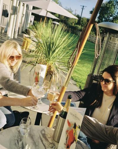 two women sitting at a table with wine glasses at voco The Club - Dublin Gateway by IHG in Naas