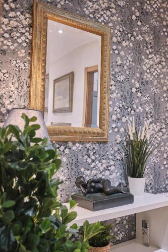a mirror on a wall with a statue on a shelf at Pensión A Solaina in O Pedrouzo