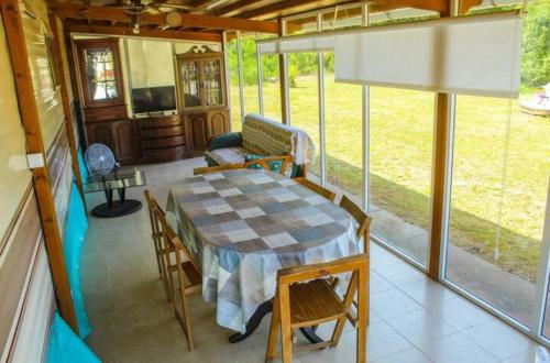a screened in porch with a table and chairs at Bungalow modulo con jardin in El Bosque
