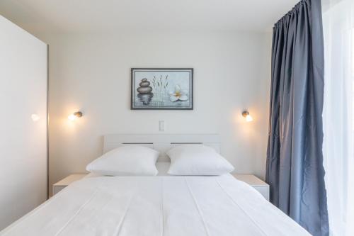 a white bed with two pillows in a bedroom at Auszeit am Deich in Nordstrand