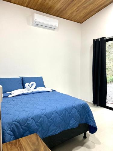 a bedroom with a blue bed with a ribbon on it at Casa Manzu in Nosara