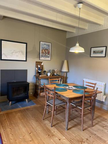 une salle à manger avec une table et une cheminée dans l'établissement Ty Jeanne classé 3 étoiles, à Ploubazlanec
