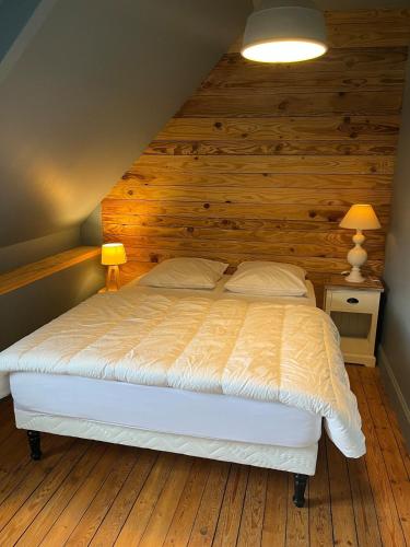 - une chambre avec un lit et un mur en bois dans l'établissement Ty Jeanne classé 3 étoiles, à Ploubazlanec