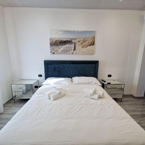 a large white bed with two towels on it at House 21 Residence Room in Collecchio