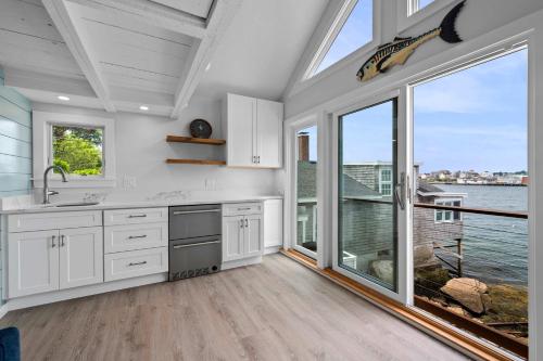 a kitchen with white cabinets and a large window at Stay at Rocky Neck in Gloucester