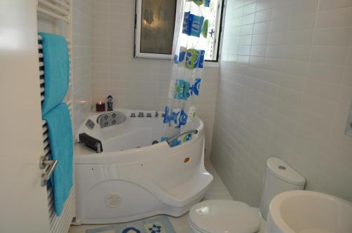 een badkamer met een bad, een toilet en een wastafel bij Katikies 22 in Pissouri