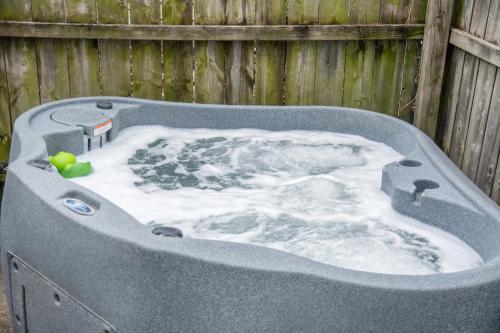 Un jacuzzi con nieve delante de una valla en Private Hot Tub & Dundee Charm Close to Attractions, en Omaha