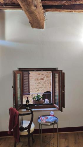 a table and a chair in a room with a window at Antica Dimora Vicolo del Tempio in Spina