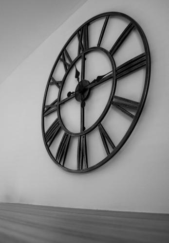 a black and white clock on a white wall at Harvest House with Games Room in Stirling