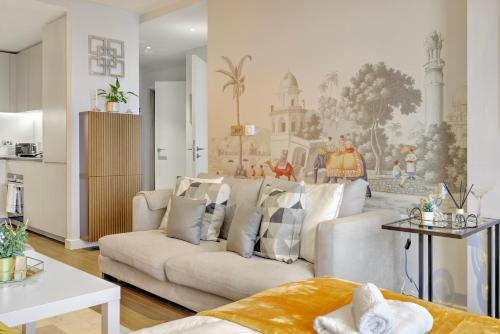 a living room with a white couch and a kitchen at Trendy 3-Bed, 2-Bath - O2 London Escape - Your Ideal Stay in London