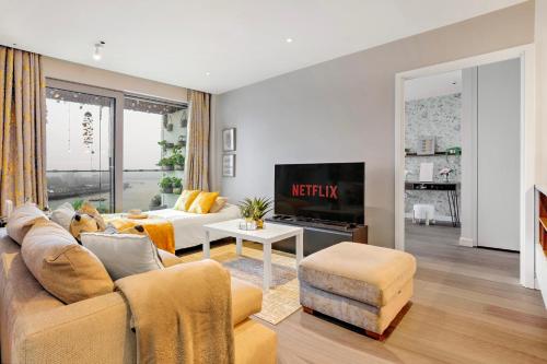 a living room with a couch and a tv at Trendy 3-Bed, 2-Bath - O2 London Escape - Your Ideal Stay in London