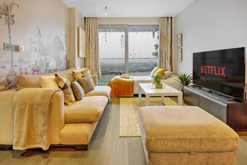 a living room with a couch and a tv at Trendy 3-Bed, 2-Bath - O2 London Escape - Your Ideal Stay in London