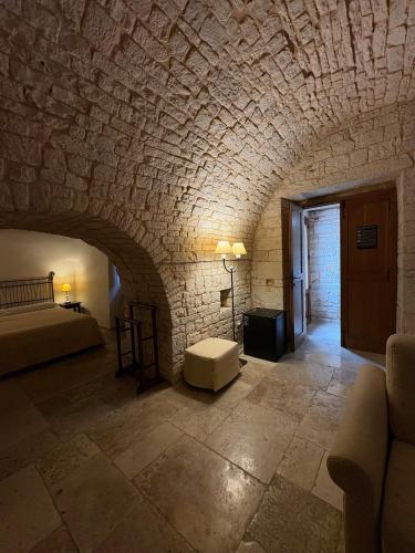 a room with a stone wall with a bed and a table at Tipico Suite in Alberobello