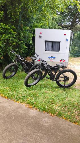 a bike parked on the grass next to a trailer at Pousada Espaço Cosmos in Águas da Prata