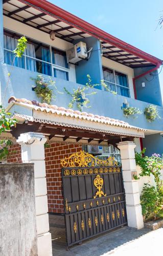 a blue house with a black gate in front of it at Ocean Pearl Cottage in Ahungalla