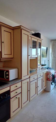 une cuisine avec des armoires blanches et un micro-ondes dans l'établissement Villa LE BELVEDERE superbe vue mer, à Saint-Raphaël