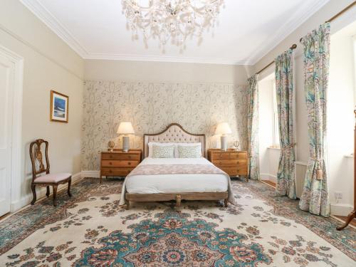a bedroom with a bed and a chandelier at North Wing - Pitmedden Gardens in Ellon