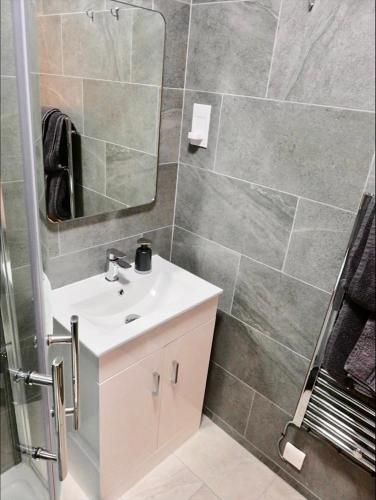 a bathroom with a sink and a mirror at Hideaway Suite in Ambleside