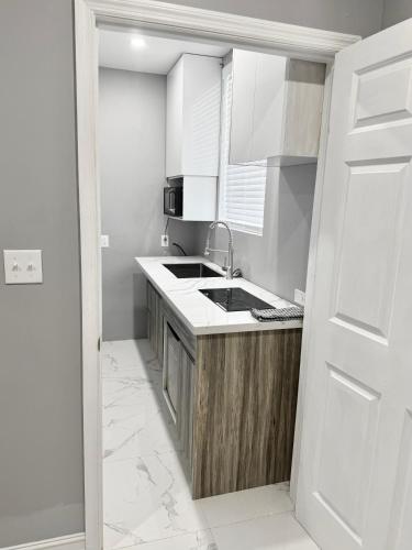 a kitchen with white cabinets and a sink at Island Haven Hideaway 5BR in Nassau