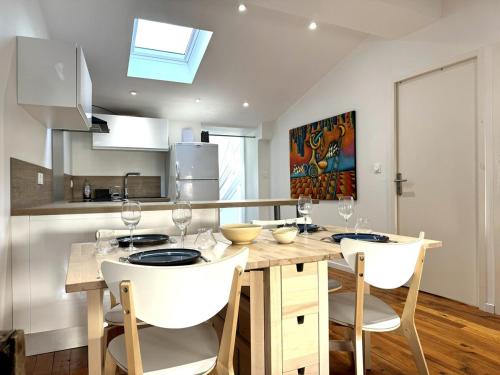 - une cuisine avec une table en bois et des chaises blanches dans l'établissement Spacieux & charmant T3, 2 chambres en hyper centre, à Vienne