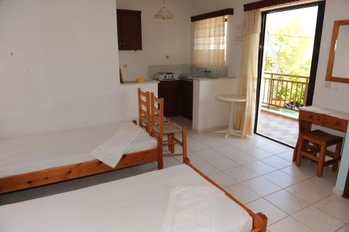 a bedroom with a bed and a kitchen with a balcony at Isavella Studios in Amoudi