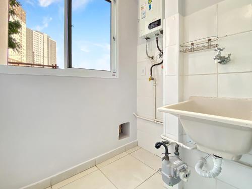 a white bathroom with a sink and a window at Pool 1 Suite 2 Bedrooms Modern Balcony in Carapicuíba
