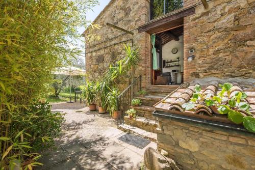una casa de piedra con una escalera que conduce a una puerta en Monolocale, en Radicondoli
