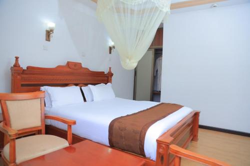 a bedroom with a bed with a chair and a table at Central Jimma Hotel in Jīma