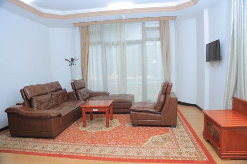 a living room with a couch and chairs and a table at Central Jimma Hotel in Jīma
