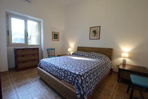 a bedroom with a bed and a desk and a window at Villa Incoronata in Torre Specchia Ruggeri