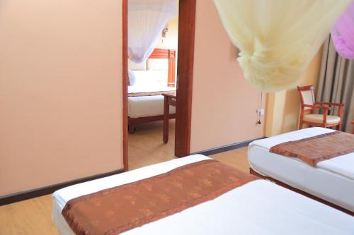 a hotel room with two beds and a mirror at Central Jimma Hotel in Jīma