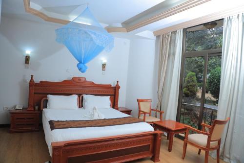 a bedroom with a bed and a large window at Central Jimma Hotel in Jīma
