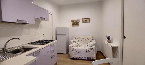 Una pequeña cocina con fregadero y refrigerador. en Freistehendes Zwei Zimmer Haus, en Peschici