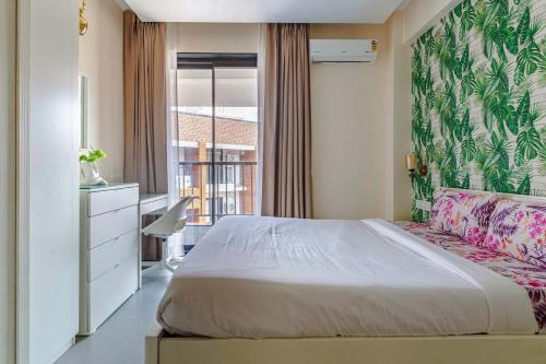 カラングートにあるOlive Door 1 BHK Suite Near Candolim beachのベッドと机と窓のある寝室