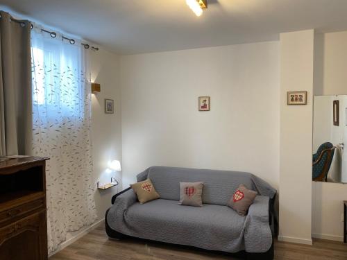 a living room with a couch and a window at Au repos des vignes, chambres d'hôtes in Rosheim