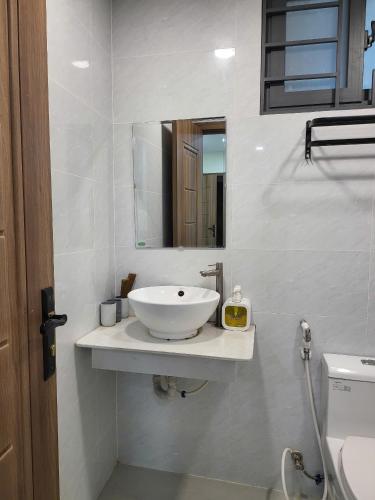 a bathroom with a white sink and a mirror at LoCo Studio with Netflix and Self Checkin in Ho Chi Minh City