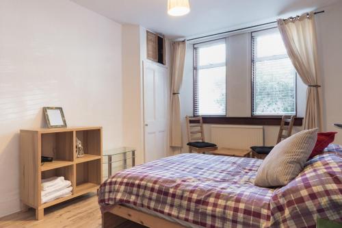 a bedroom with a bed and two windows at Aberdeen City Flat, close to city centre in Aberdeen