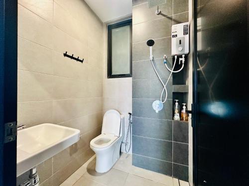 une salle de bain avec toilettes et lavabo dans l'établissement Comfortable 2BR 5 Queen Beds, Netflix & Free Parking, à Jelutong
