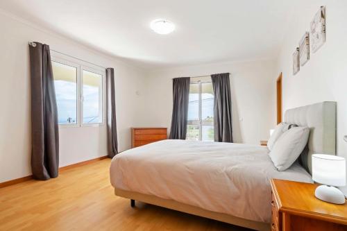 Un dormitorio con una cama y una ventana grande. en SunRise Vila, en Estreito da Calheta