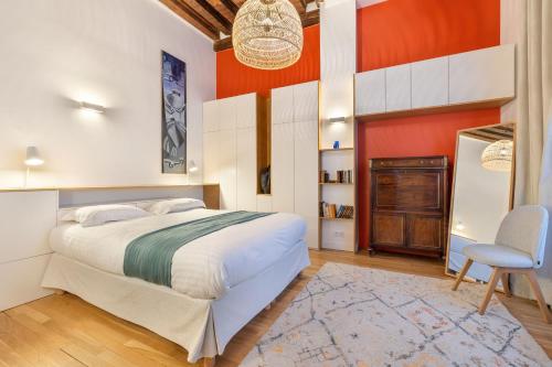 une chambre avec un grand lit et une chaise dans l'établissement Mousquetaire, à Paris